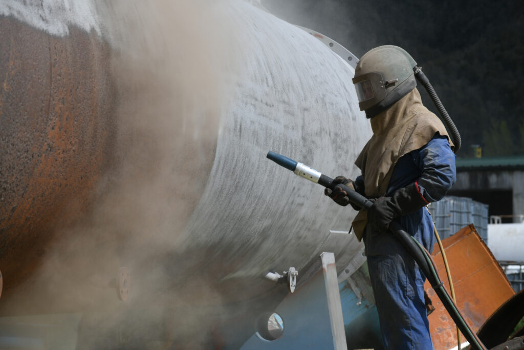 engineer sandblasting a steel casing